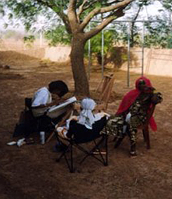Louise Cutler drawing a women in the village of Golmi (Africa)